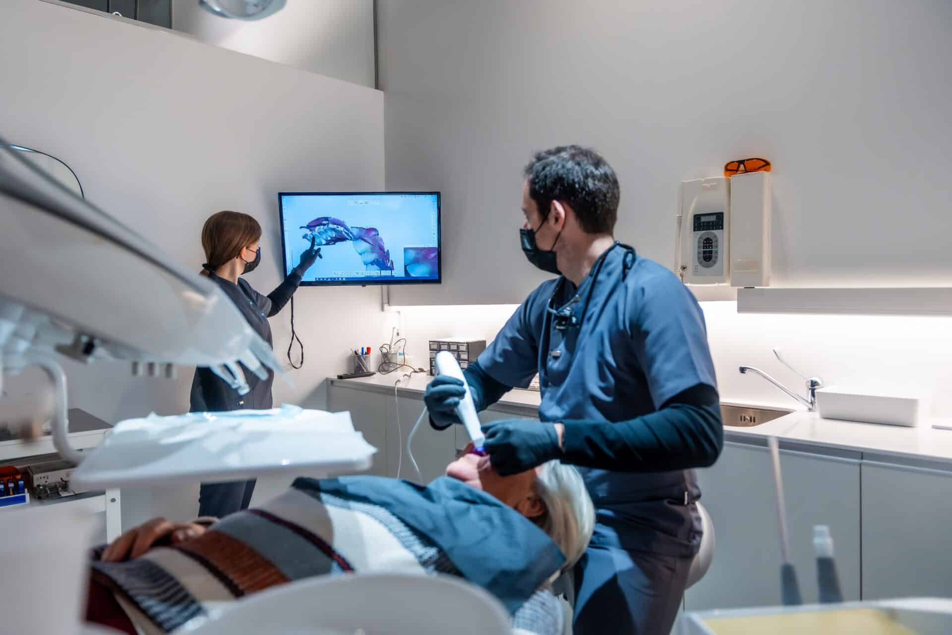 Dentists showing teeth x ray to patient during treatment in modern clinic